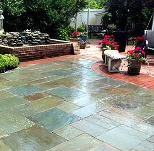 wet and shiny new patio made from brick and slate stone